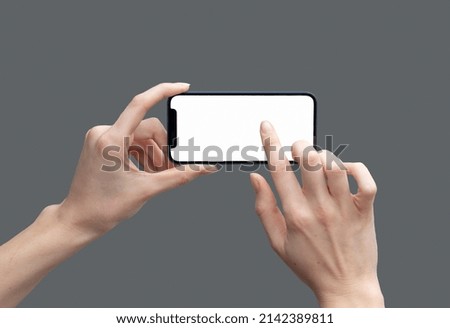 Hands taking picture using mobile phone on grey background.