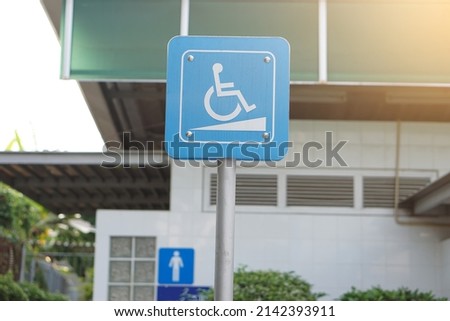 Blue sign with symbol of person sit on wheelchair in front of public toilet at gas station in Thailand to service  and facilitate for disabled people.                           