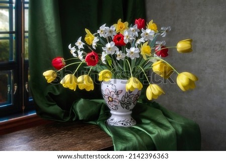 Still life with bouquet of tulips and daffodils  in the interior