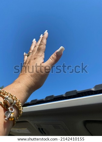 Freedom on the sunroof of a car in a beautiful blue sky