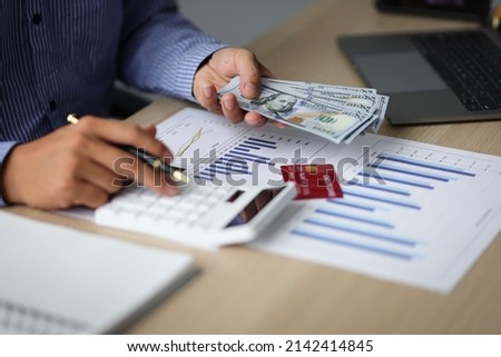 Close-up businessman holding banknotes and counting money. Accounting concept Financial Planning and Investment Profitability Analysis