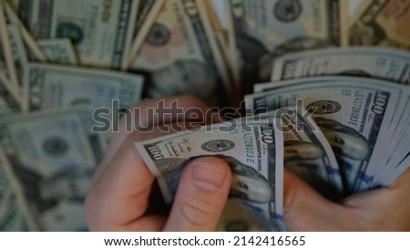 Male hands counting American one hundred dollar bills against the background of smaller bills of money lying on the table Royalty-Free Stock Photo #2142416565