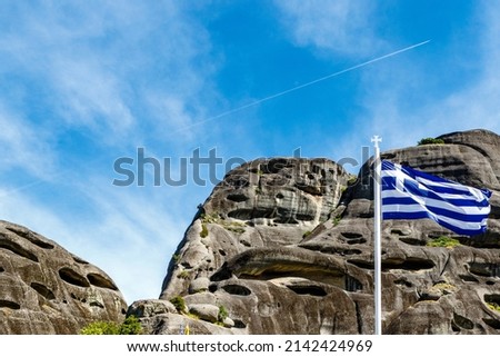 Greek flag and black rocks in Meteora, Greece, Europe