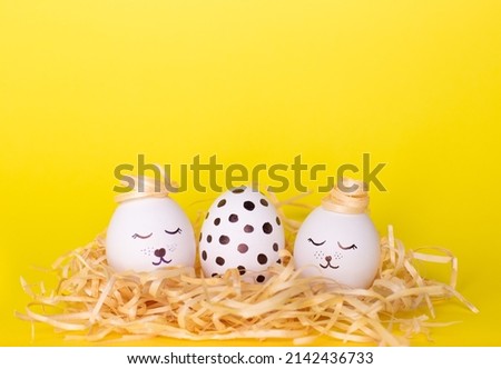 Easter eggs in the nest. With dots and faces on the yellow background. Easter concept. Space for text