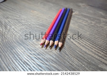 The pencils laying on the wooden table. Closeup photo of the pencils. 