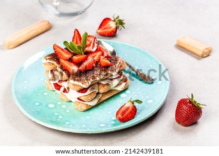 Strawberry tiramisu with mascarpone. Summer dessert, classic tiramisu with strawberries decorated with mint leaves. Royalty-Free Stock Photo #2142439181