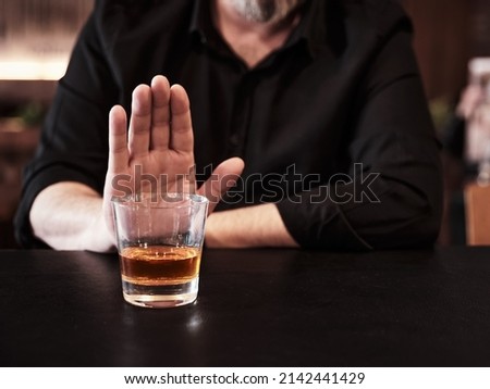 Man refuses or rejects to drink alcohol at the pub. Alcohol addiction treatment, sobriety and drinking problem. Royalty-Free Stock Photo #2142441429