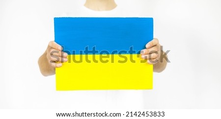 Guy with paper in the form of a yellow and blue flag of Ukraine on a white background.