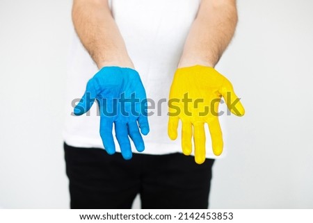 Man's hands are painted in yellow and blue. Stop the war. People against the war. Independence of Ukraine. Flag. The concept of love for Ukraine.