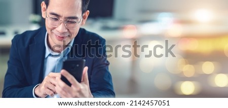 Businessman using smartphone and laptop, view taken from elephant side.