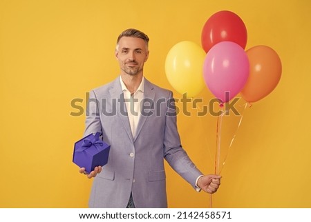 present and gifts buy. shopping guy with purchase on yellow background. business reward