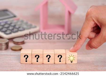 The process of problem solving or idea formation. Question mark and light bulb icons on wooden cubes with female hand on blue background.                          