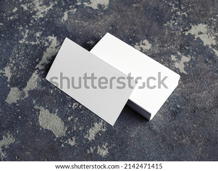 Blank white business cards on concrete background. Mockup for branding identity. Template for graphic designers portfolios.
