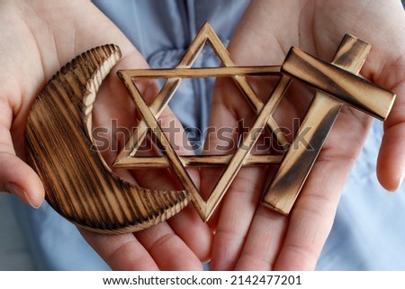 Christianity, Islam, Judaism  3  monotheistic religions. Jewish  Star, Cross and Crescent :  Interreligious symbols in hands.  Religious and faith concept.  06-30-2018 Royalty-Free Stock Photo #2142477201
