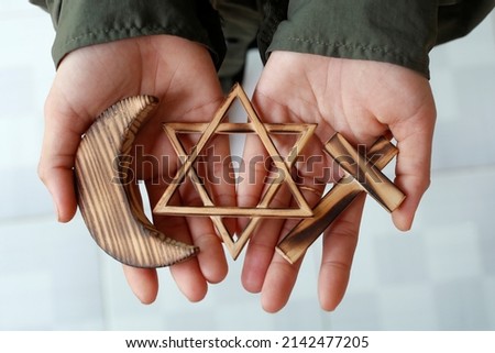 Christianity, Islam, Judaism  3  monotheistic religions. Jewish  Star, Cross and Crescent :  Interreligious symbols in hands.  Religious and faith concept.  06-30-2018 Royalty-Free Stock Photo #2142477205