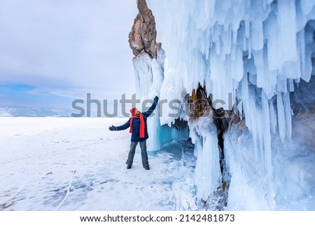 Man tourist adventure landscape background blue ice cave and grotto winter from lake Baikal Russia.