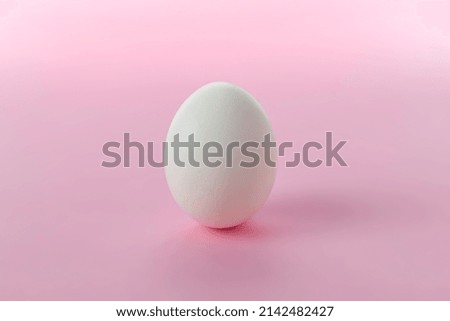 White egg on a pink background.Postcard with space for text