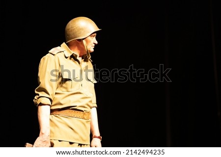 Actor in military uniforms of the Soviet army of World War II play a performance on stage in the theater