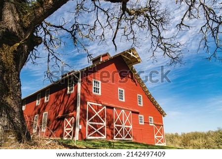 Beautiful Red and White Wooden Barn and Colorful Blue Sky and Clouds. Royalty-Free Stock Photo #2142497409
