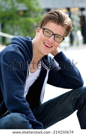 Close up portrait of a confident young man smiling outdoors