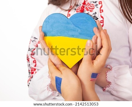 Children support a heart with the colors of the Ukrainian flag w
