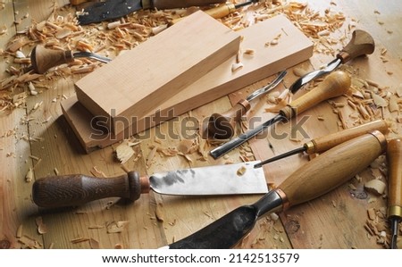 Timber, wood processing. Joinery work. Wood carving with work tools close up. Hand of carver carving wood. Craftsman carving with a gouge Royalty-Free Stock Photo #2142513579