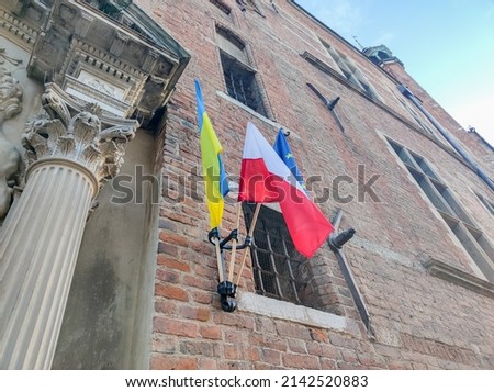 Ukraine, Polish and Europe Union flags on the brick wall.