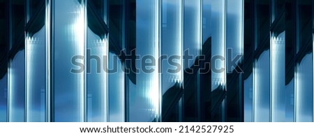 Abstract architecture of modern building with glazed windows. Panoramic photo of glass panels and metal frames of facade wall. Fragment of business real estate. Geometric pattern of parallel lines.
