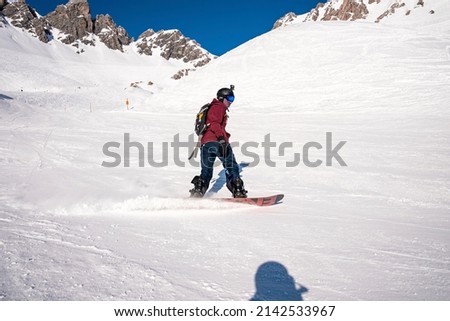 Skier skiing on snow covered mountain. Tourist enjoying winter sport during sunny day. Ski tracks on white landscape.
