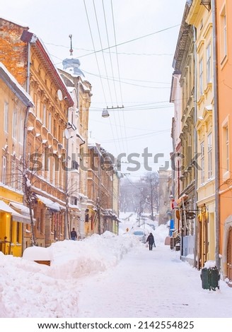 Snow covered street of Lviv old town with cafes and restaurants, winter Lviv cityscape, Ukraine