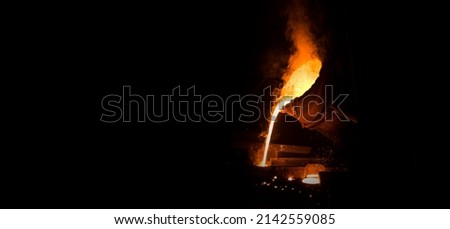 View of industrial metal casting. The process of for filling out mold with molten metal. Industrial panoramic view with black writing area. Royalty-Free Stock Photo #2142559085