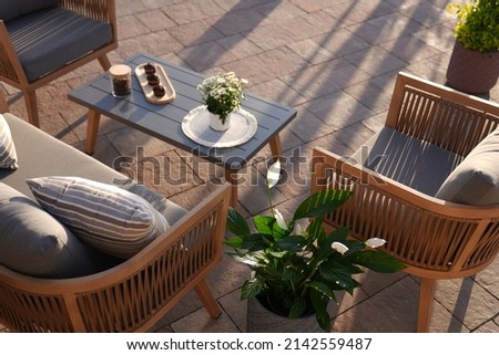 close up,wood sofa and table made of metal and wood in the yard and garden on the garden tiles Royalty-Free Stock Photo #2142559487