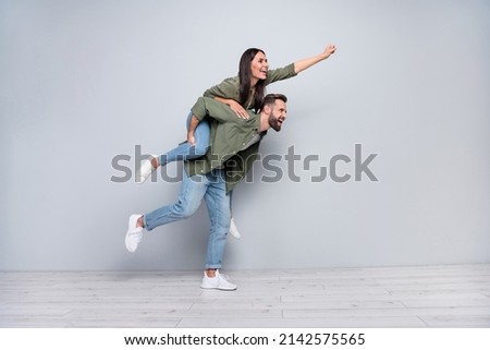 Full size profile side photo of young cheerful couple have fun walk strong look empty space isolated over grey color background