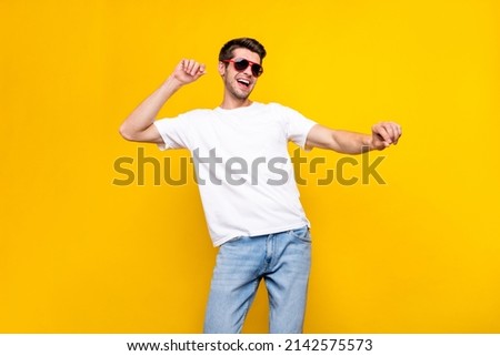 Photo of cool young brunet guy dance wear glasses t-shirt isolated on yellow color background Royalty-Free Stock Photo #2142575573