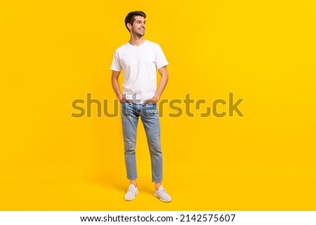 Full body photo of cute young brunet guy stand look ad wear eyewear t-shirt jeans sneakers isolated on yellow background Royalty-Free Stock Photo #2142575607