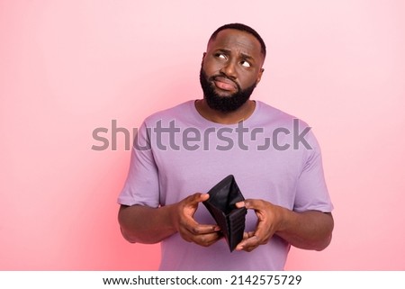 Photo of suspicious unsure young guy wear purple t-shirt thinking how earn money isolated pink color background