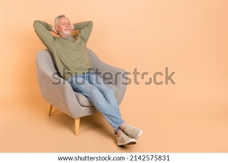 Full size photo of sleepy old grey hairdo man sit wear pullover jeans shoes isolated on beige background Royalty-Free Stock Photo #2142575831