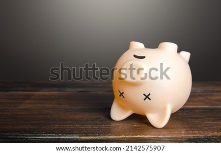 Dead piggy bank lies upside down. Economic depression. Financial crisis, end of savings, bankruptcy. Devaluation, inflation. Impoverishment. Refinancing restructuring of debts. Royalty-Free Stock Photo #2142575907