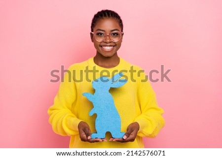 Photo of funny positive girl hold rabbit figure toothy smile look camera isolated on pink color background
