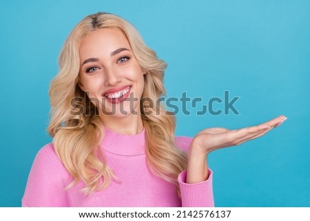 Photo of nice millennial blond lady hold empty space wear pink jumper isolated on blue color background