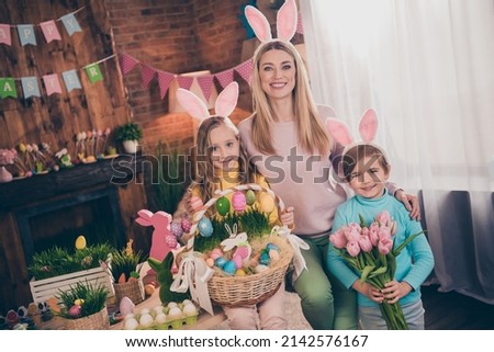 Photo of cheerful good mood mother hug embrace her children celebrate easter spring holiday have fun indoors