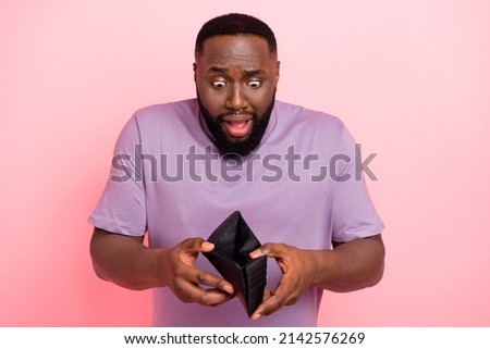 Photo of unhappy upset young guy wear purple t-shirt lost all money isolated pink color background