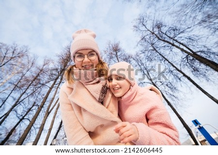 mother and daughter happily embrace spring walk in the park sunny day. High quality photo