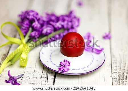 Easter composition with egg and egg cup with Hyacinth spring flowers on wooden background