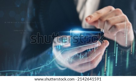 Business, finance and investment, forex trading, currency exchange, economic growth, stock market analysis concept. Man using mobile phone checking stock market graph report via mobile apps Royalty-Free Stock Photo #2142641591