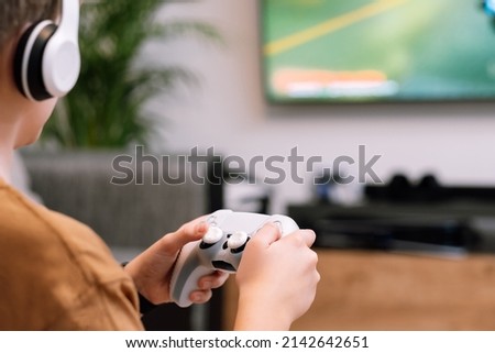 Close-up of teenager boy's hands holding joystick. Concept of playing on the console. Royalty-Free Stock Photo #2142642651