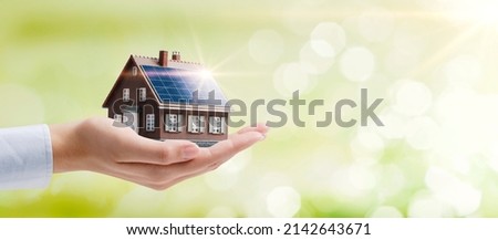 Hand holding an energy efficient model house with solar panels, ecology and sustainability concept Royalty-Free Stock Photo #2142643671