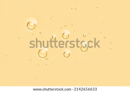 Yellow oil toner serum background. Skincare liquid surface with bubbles. Abstract cosmetic product macro
