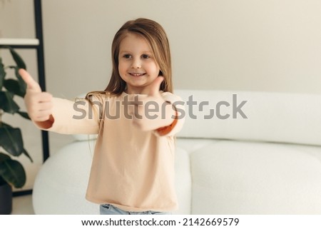 portrait of a cute smiling little girl at home. girl shows like