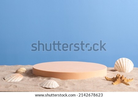 Empty round beige platform podium with sea shells and starfish on white beach sand background. Minimal creative composition background for cosmetics or products presentation. Front view